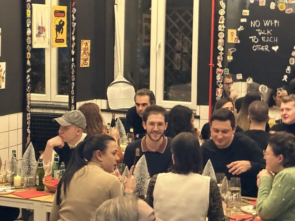 [rezidentz] tenants enjoying a meal and conversation at La Bottega de la Pizza. Community bonding and vibrant moments in Brussels