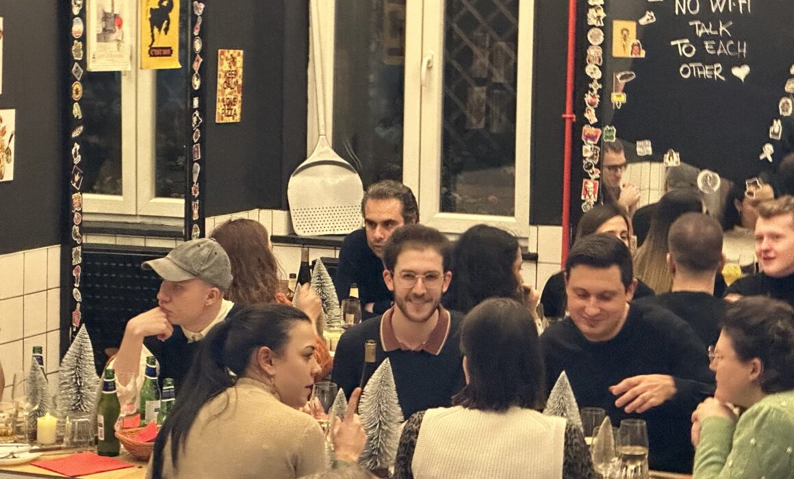 [rezidentz] tenants enjoying a meal and conversation at La Bottega de la Pizza. Community bonding and vibrant moments in Brussels